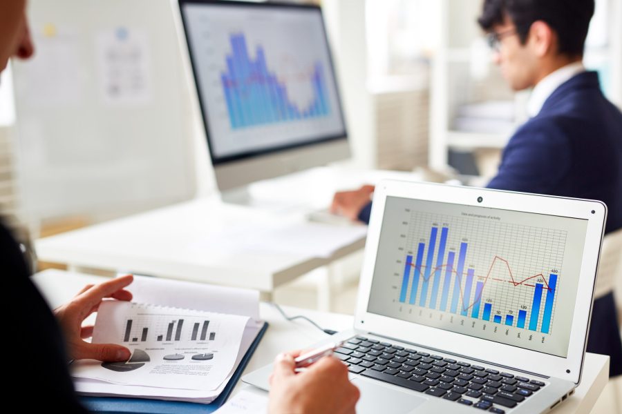 Statistics chart on laptop display and trader analyzing the data